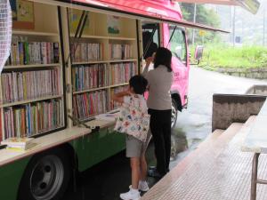 先生と本を選ぶ子ども