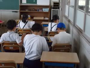 サマースクールで小学生に勉強を教える中学生
