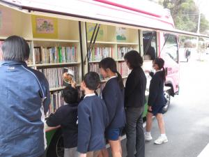 自動車図書館で本を選ぶ児童