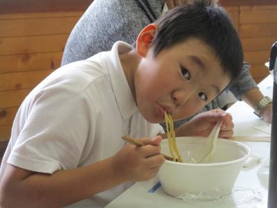 ラーメンを食べる児童
