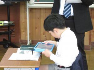 ノートの写真を撮る児童