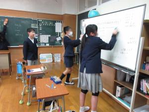 ホワイトボードの字を消す6年生