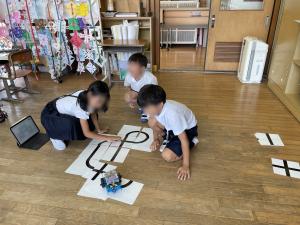 7月9日：錦清流小学校との合同学習を行いました。算数では、みんなでぐるっと回る線路を考えて、エムボットを走らせました。はじめは、タブレットを使って個別に考え、それをもとにグループで意見を出し合いました。自分たちが作ったコースをエムボットが走ると、大喜びして
