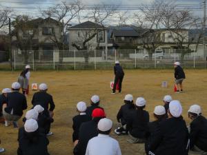 児童が消化器で火を消す練習をしている画像