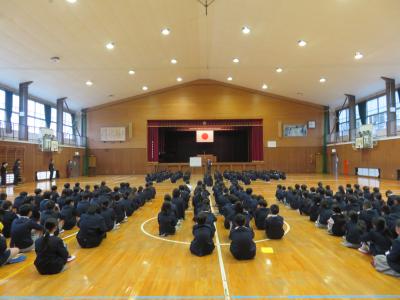 児童が体育館で先生の話を聞いている画像