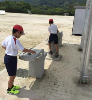 全校練習での休憩のひととき，水を飲んでいます。