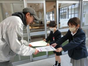 牛乳配送の方に礼状を渡す様子